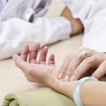 doctor taking a female patient's pulse.